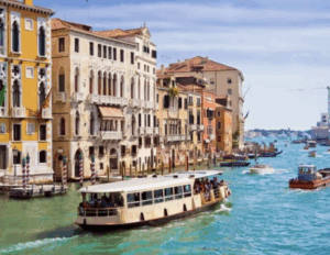 Vue depuis un vaporetto naviguant sur le Grand Canal à Venise, bordé de palais vénitiens historiques et de façades colorées.